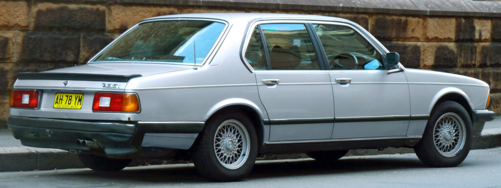 Silberner BMW 735i der Baureihe E23 von schräg hinten