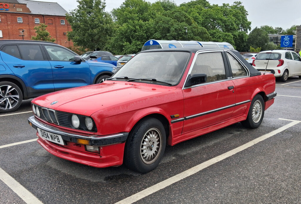 BMW 325i E30 in Rot, zweitürig, Frontansicht schräg von rechts