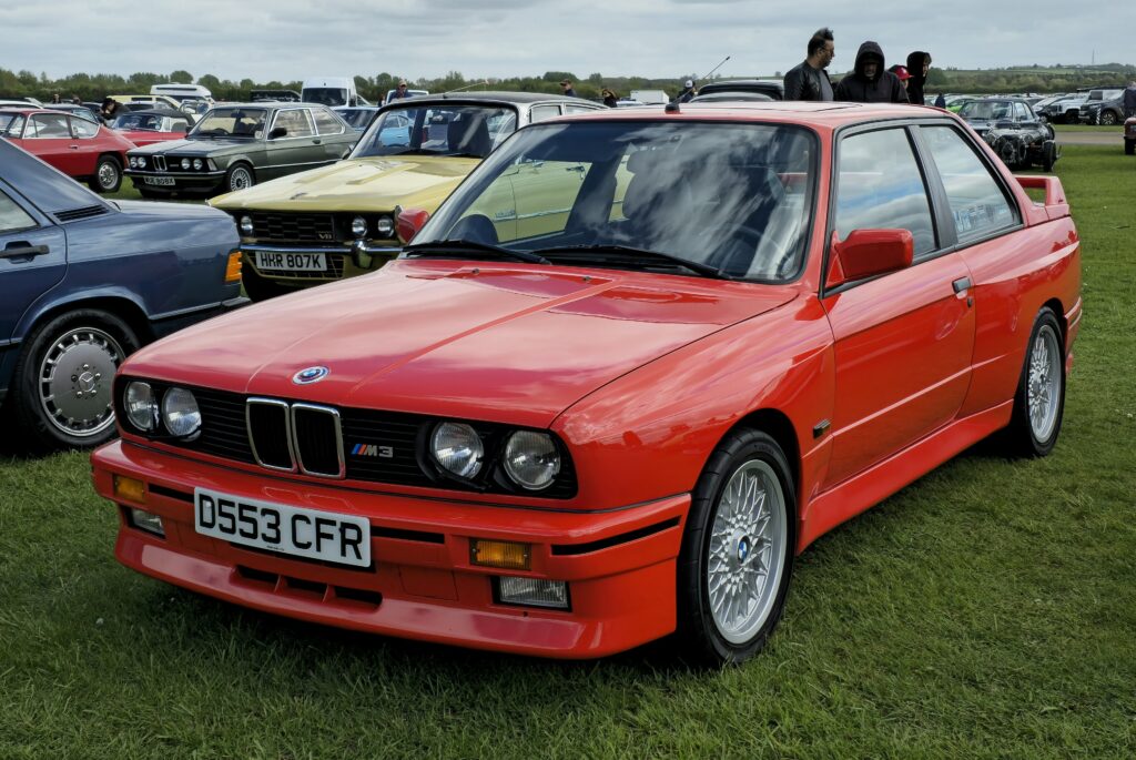 BMW M3 E30 in Rot, Heckansicht schräg von rechts
