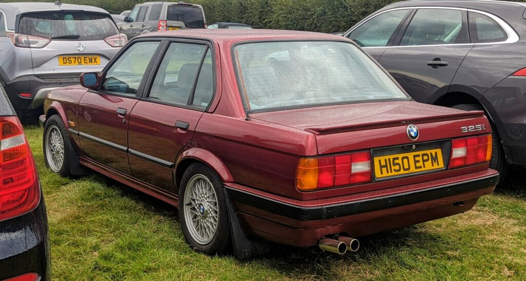 BMW 325i E30 viertürig in Dunkelrot, Heckansicht schräg von links