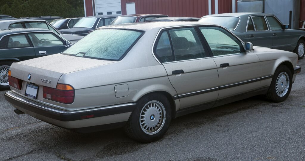 Silberner BMW 735i der Baureihe E32 von schräg hinten