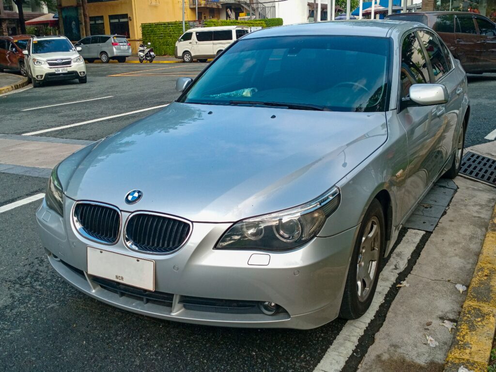Silberner BMW 5er der Baureihe E60 von vorn links