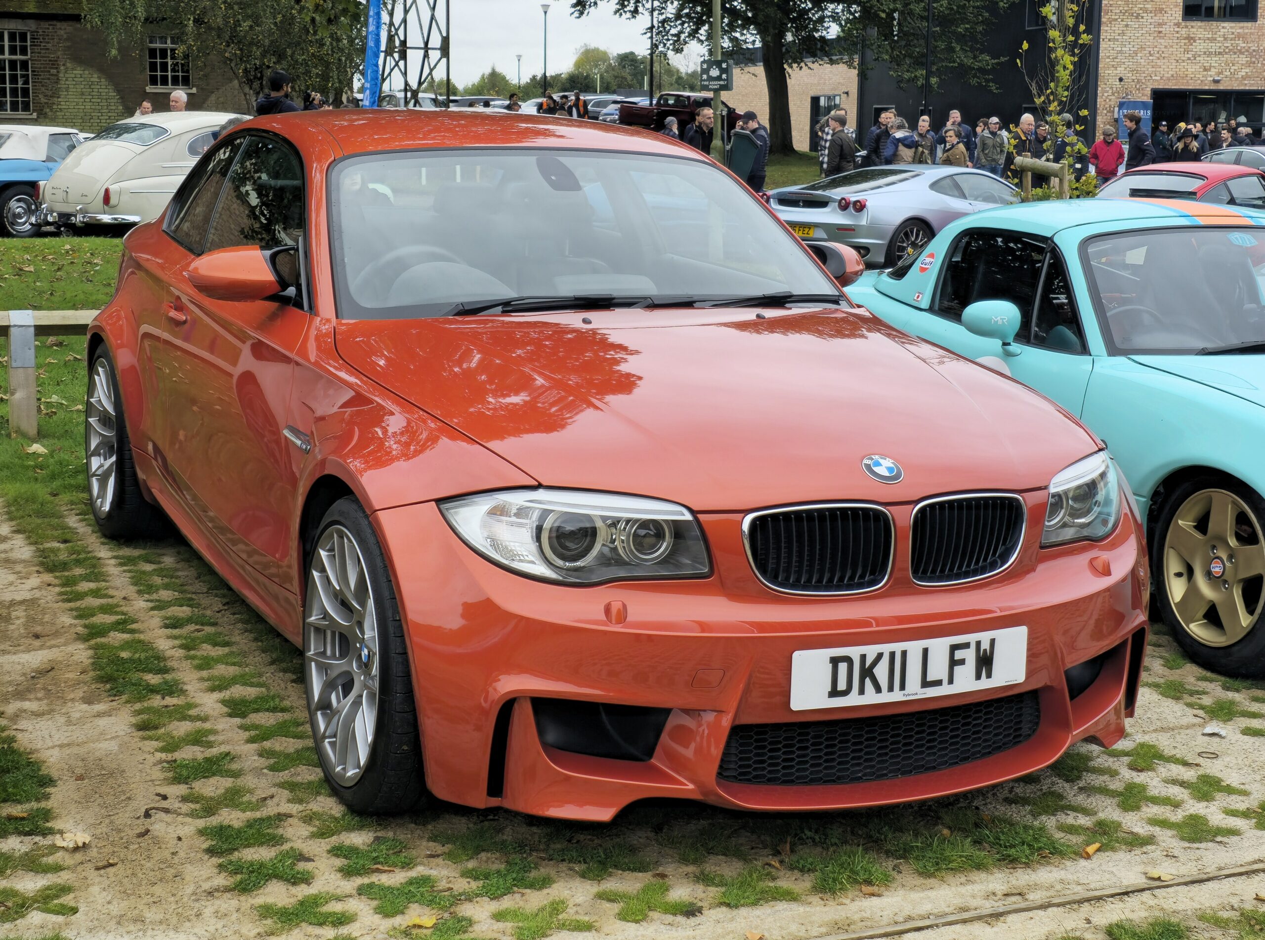 Orangefarbenes BMW 1er M Coupé in Dreiviertelansicht von vorn