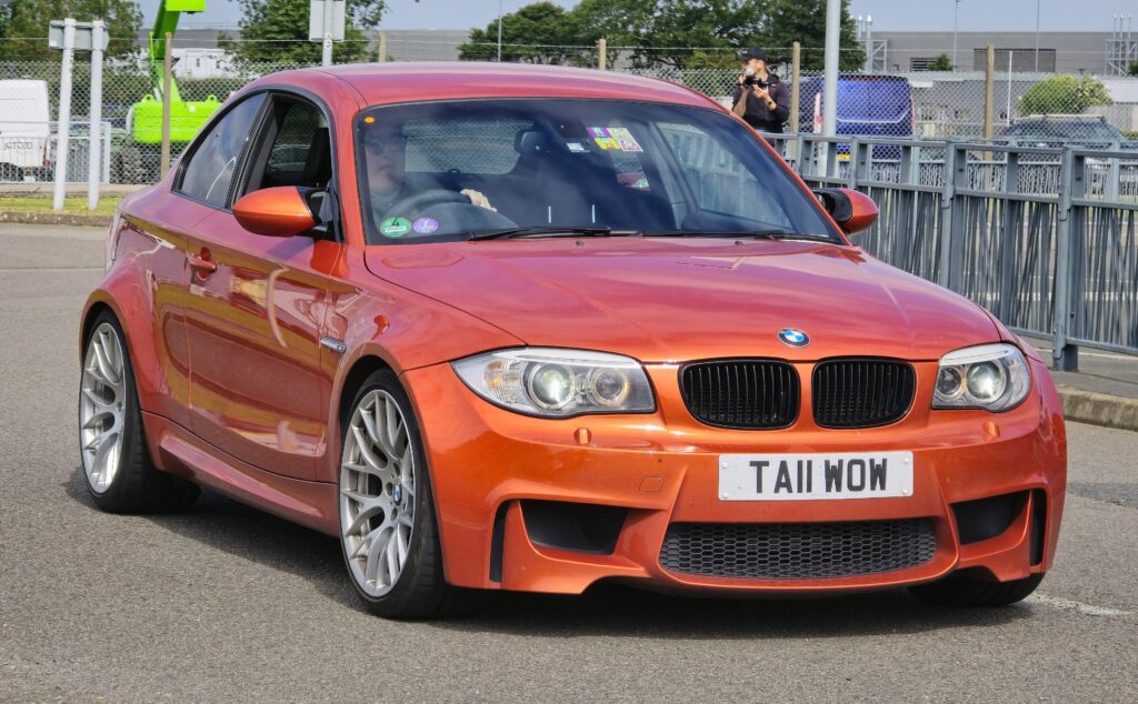 Orangefarbenes BMW 1er M Coupé von vorn