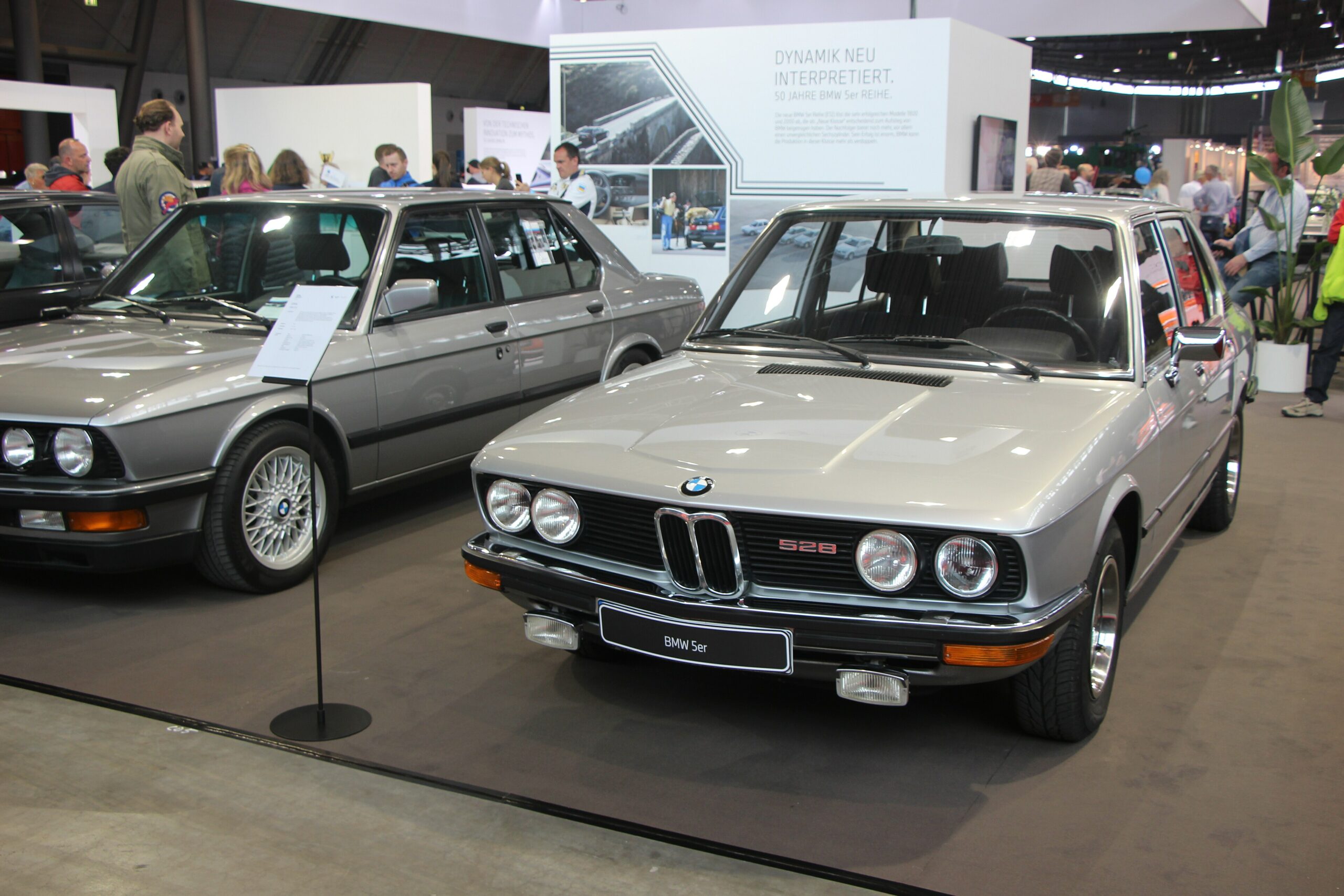 Silberner BMW 528 der Baureihe E12 von schräg vorn in einer Ausstellungshalle