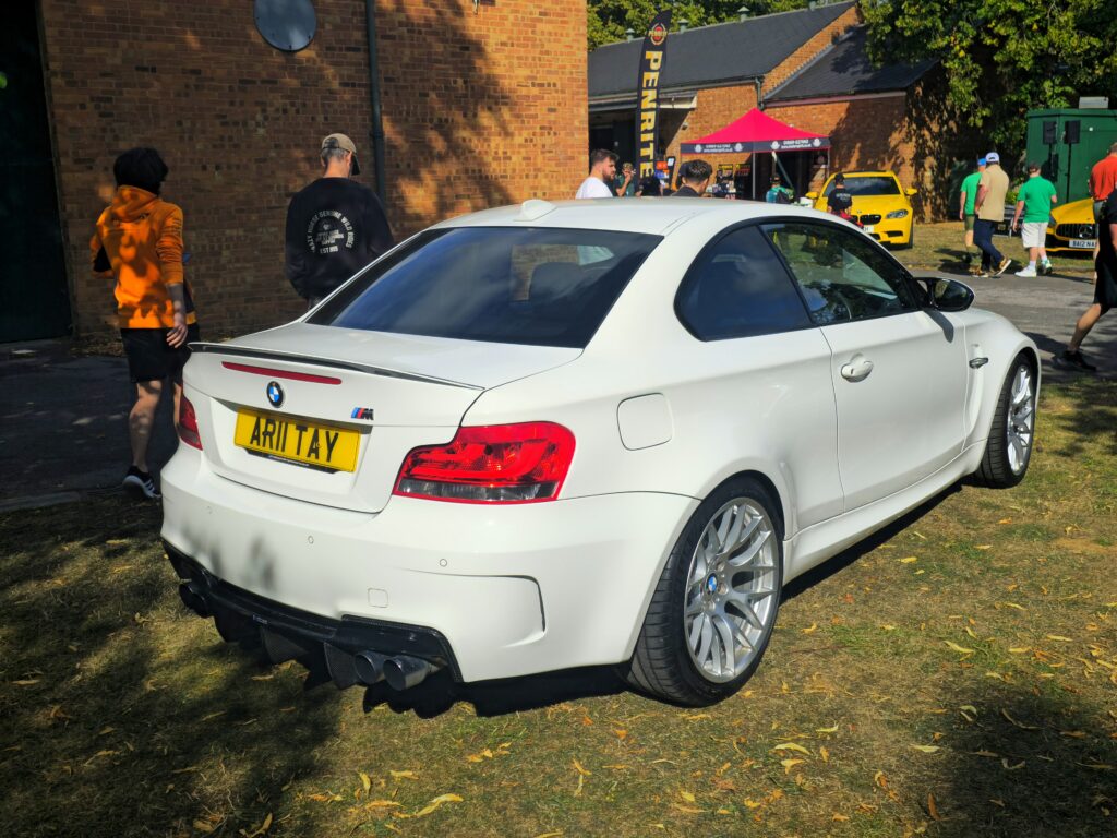 Weißes BMW 1er M Coupé von hinten