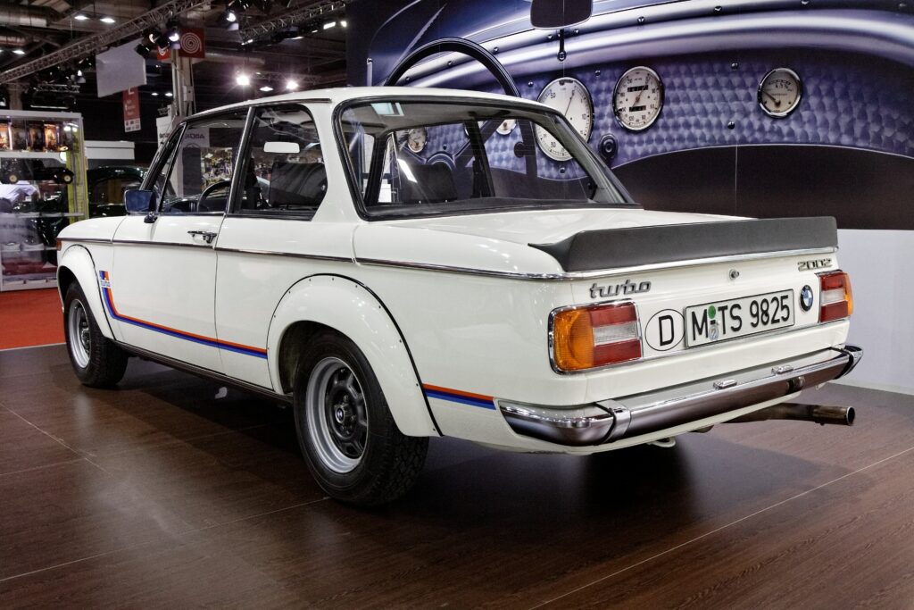 Weißer BMW 2002 turbo von hinten mit Gummi-Heckspoiler