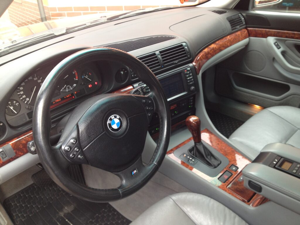 Cockpit eines BMW 735i der Baureihe E38 mit Lenkrad und Holzdekor