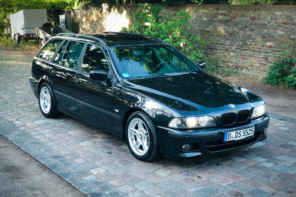 Schwarzer BMW 525i Touring der Baureihe E39 in Schrägansicht von vorn rechts