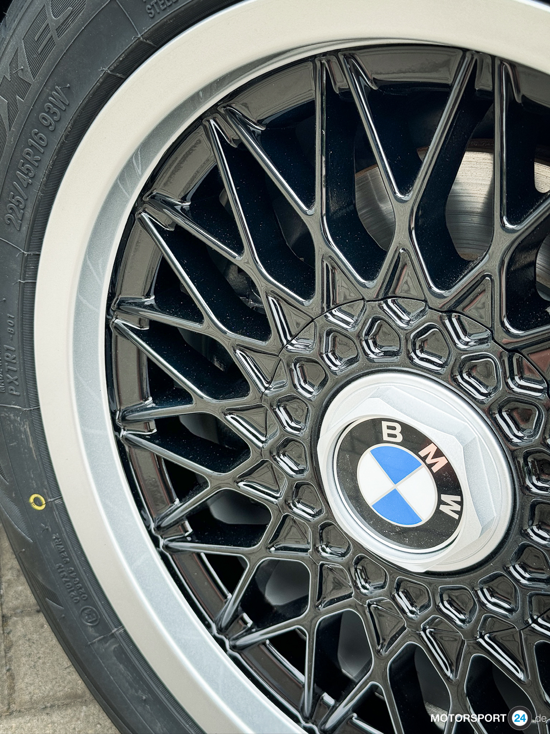 Schwarzer Felgenstern der BBS-Kreuzspeichenfelge am BMW M3 E30 Cecotto — glänzende Oberfläche, silberner Felgenrand