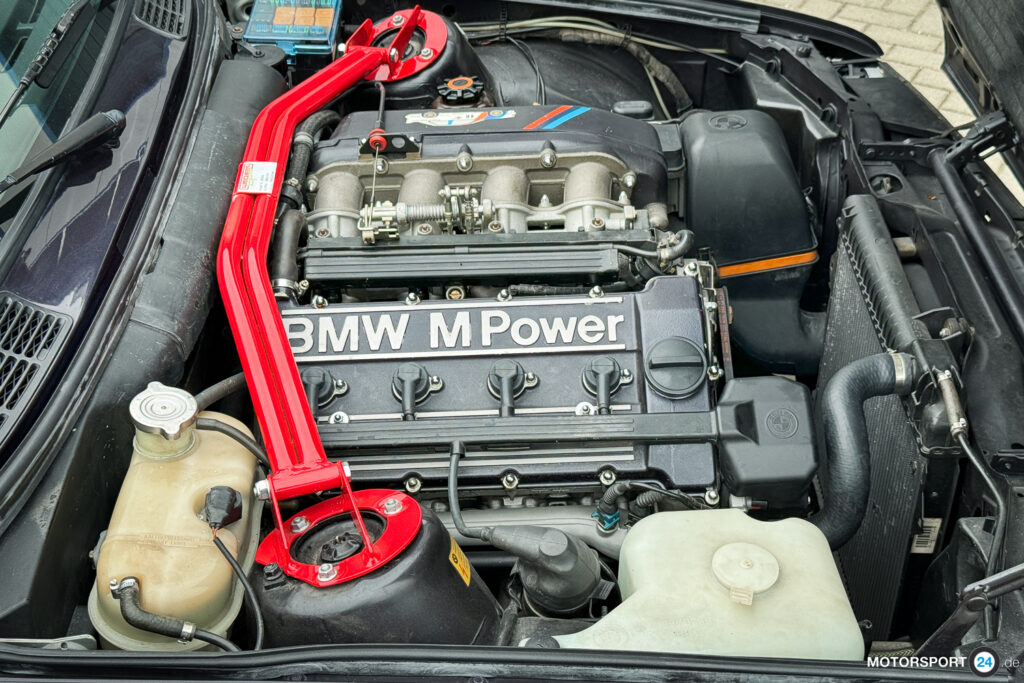 Motorraum eines BMW M3 E30 Cecotto mit Ventildeckel und Sauganlage in Wagenfarbe Macaoblau