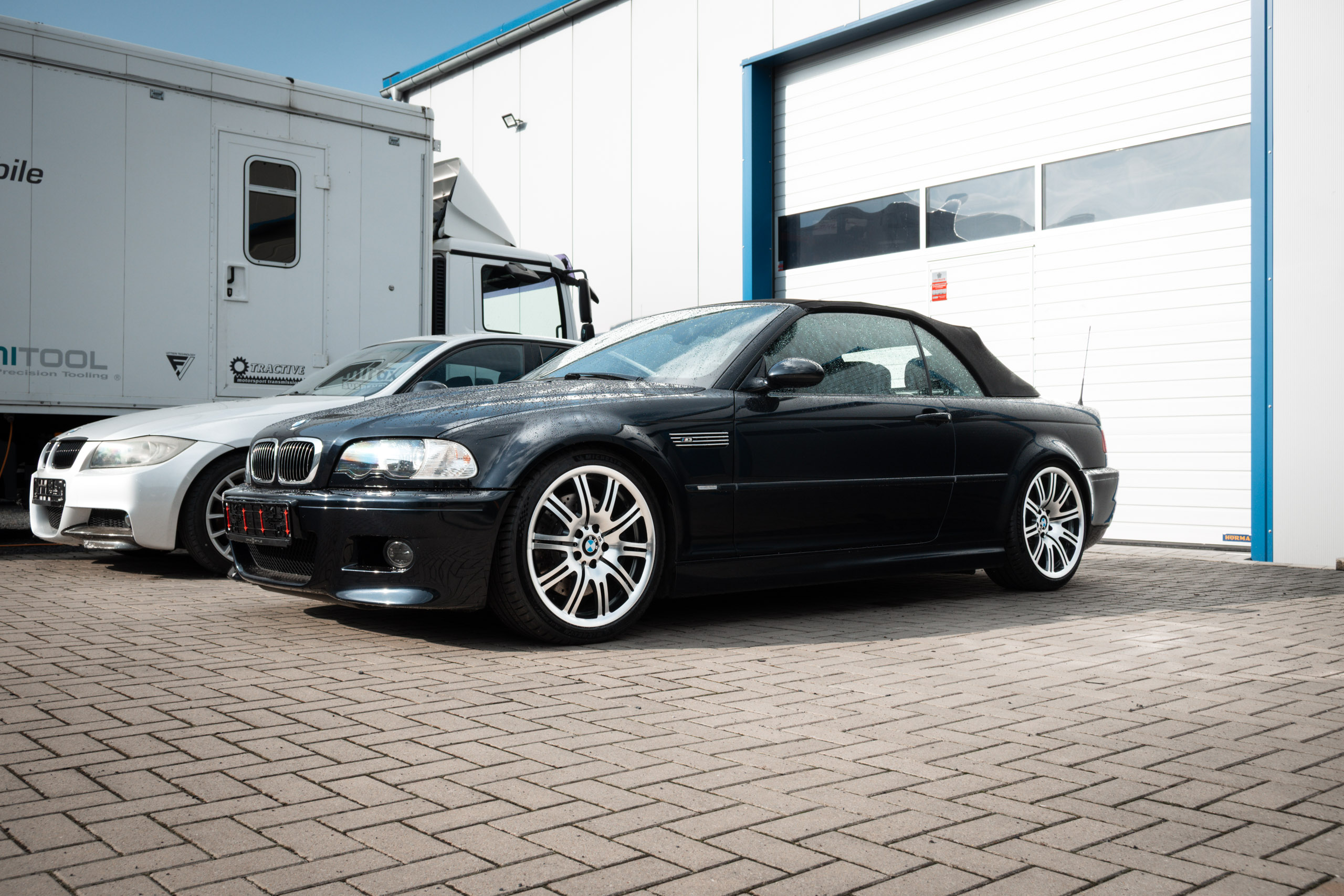 Schwarzes BMW M3 Cabriolet der Baureihe E46 mit geschlossenem Verdeck, Schrägansicht von vorn