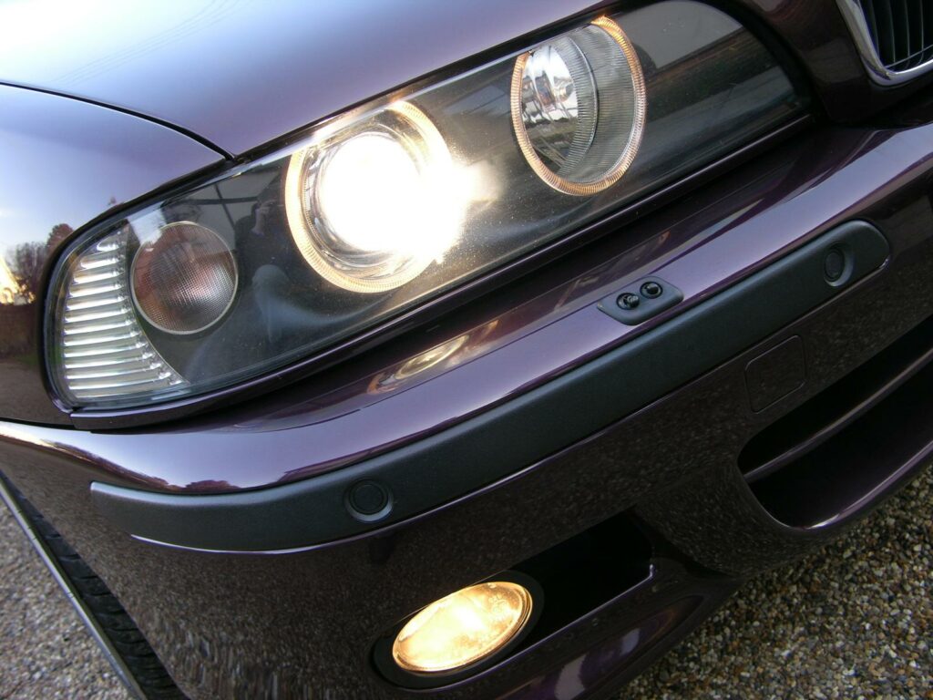Nahaufnahme des Doppelscheinwerfers eines BMW E39 mit leuchtendem Standlichtring