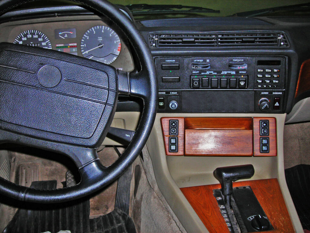 Innenraum eines BMW der Baureihe E23 mit Lenkrad, Mittelkonsole und Holzdekor