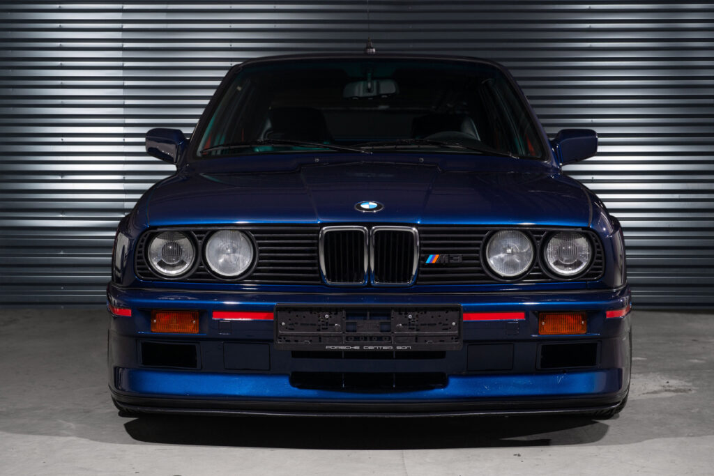 BMW M3 E30 Sport Evolution in Mauritiusblau (AC79200) — Frontansicht mit Doppelscheinwerfern, BMW-Niere und Frontspoiler