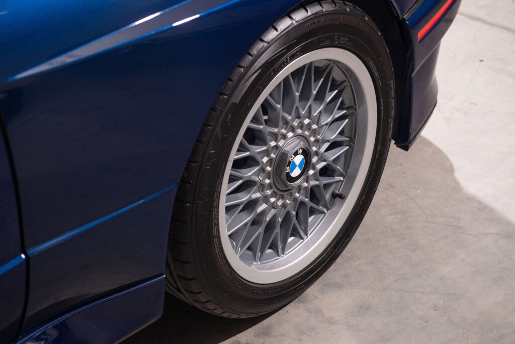 BMW M3 E30 Sport Evolution in Mauritiusblau (AC79200) — Vorderrad mit BBS-Kreuzspeichenfelge, Felgenstern in Nogarosilber