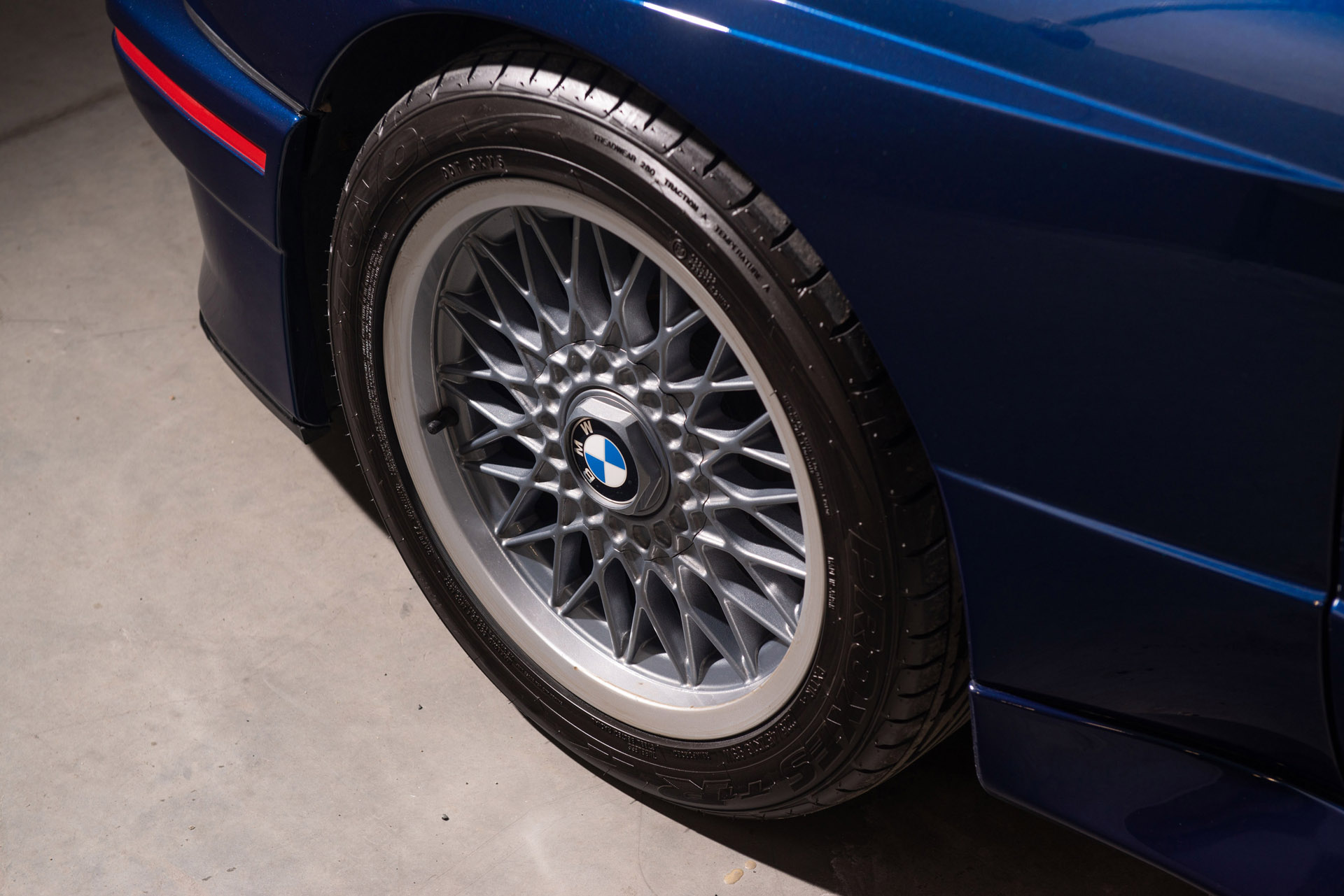 BMW M3 E30 Sport Evolution in Mauritiusblau (AC79200) — Vorderrad mit BBS-Kreuzspeichenfelge, Felgenstern in Nogarosilber