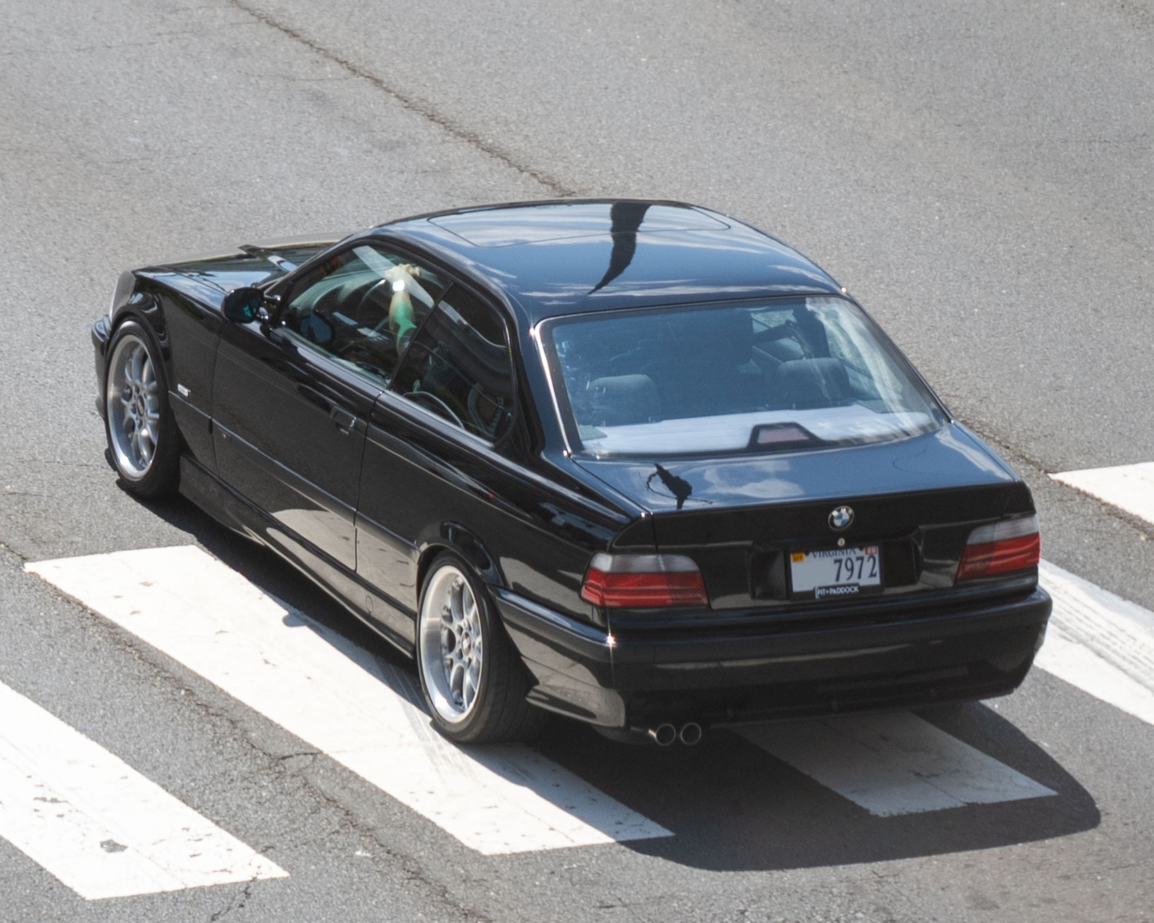 Schwarzes BMW 328i Coupé der Baureihe E36 in erhöhter Schrägansicht
