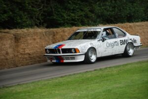 Weißer BMW 635 CSi Gruppe A Tourenwagen mit BMW-Motorsportstreifen in Fahrt