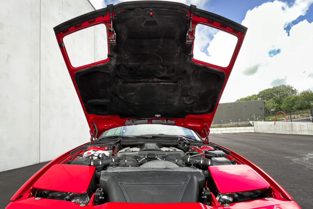BMW 850Ci der Baureihe E31 in Rot mit geöffneter Motorhaube