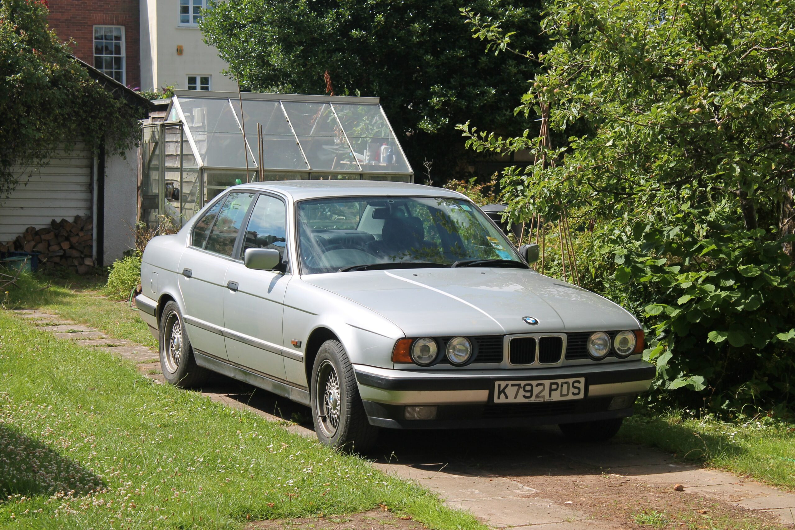 Silberne BMW 525i Limousine der Baureihe E34 von schräg vorn links