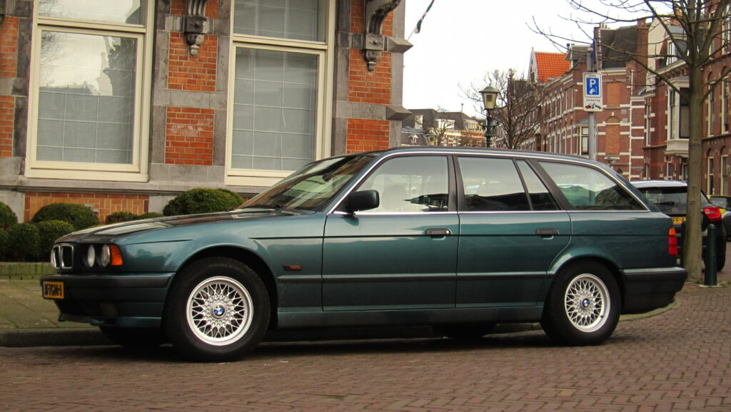 Grüner BMW 540i Touring der Baureihe E34 von der Seite