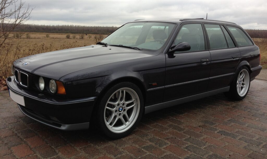 Schwarzer BMW M5 Touring der Baureihe E34 von schräg vorn links
