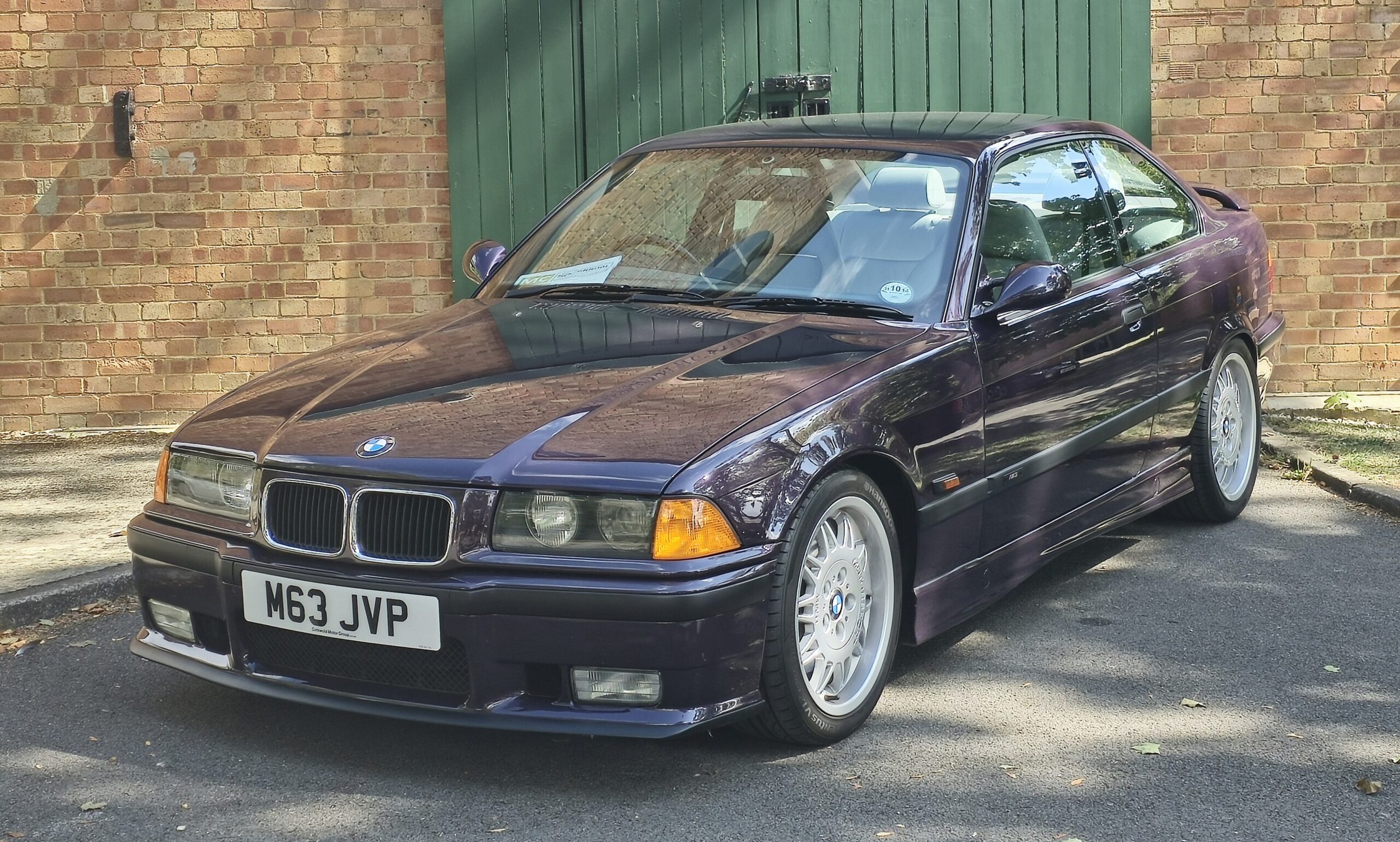 BMW M3 Coupé der Baureihe E36 in dunklem Violett, Ansicht von schräg vorn rechts