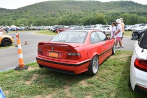 BMW M3 Coupé E36 in Hellrot, Heckansicht bei einer Veranstaltung