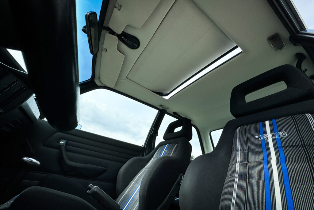 Innenraum eines BMW 320i der Baureihe E21 mit geöffnetem Schiebedach