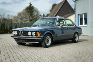 BMW 320i der Baureihe E21 in Arktisblau metallic vor einem Wohnhaus