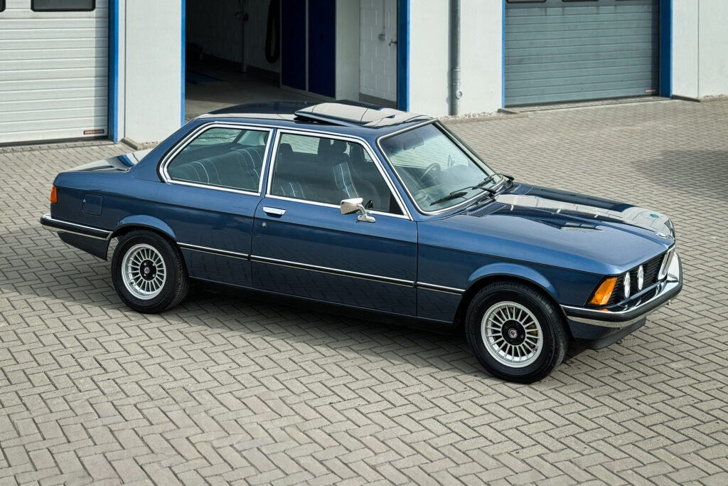 BMW 320i der Baureihe E21 in Arktisblau metallic vor einer Werkstatthalle