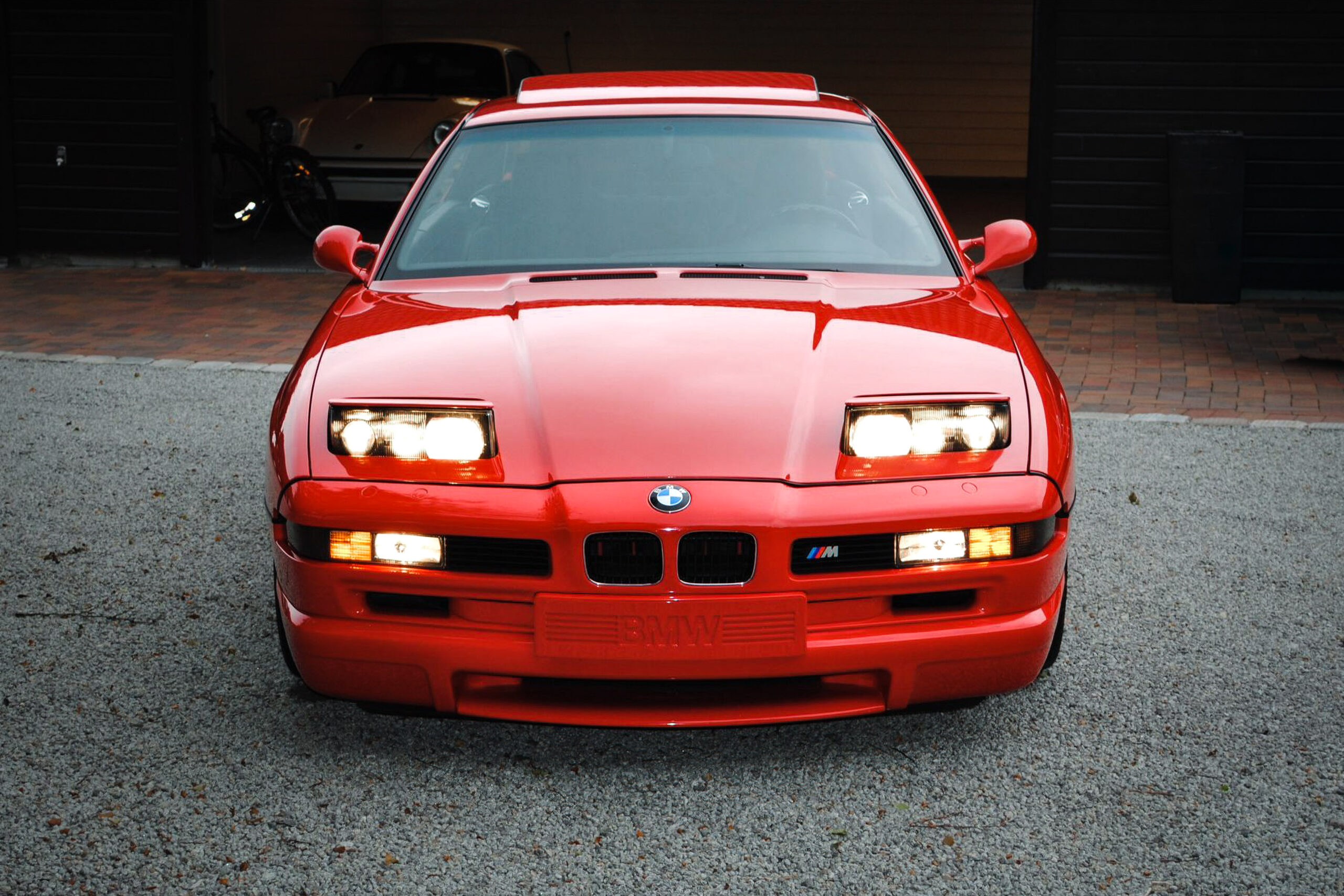Front eines hellroten BMW 850CSi mit ausgefahrenen Klappscheinwerfern